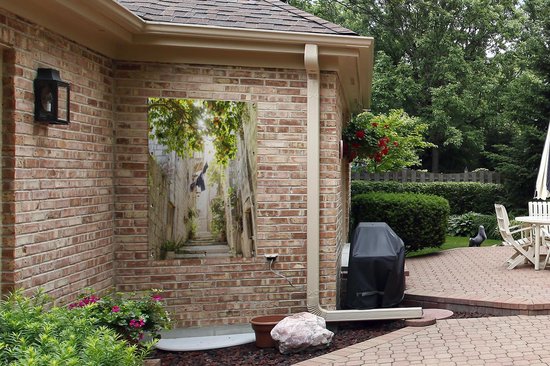 Tuinposter - Tuindoek - Tuinposters buiten - Een sinaasappelboom in een smalle steeg - 80x120 cm - Tuin