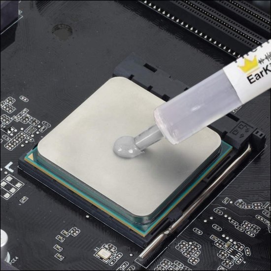 Een grijze koelpasta wordt aangebracht op een CPU met een spuitje.