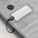 Grijze, zachte deken met aan/uit knop en aangesloten powerbank.