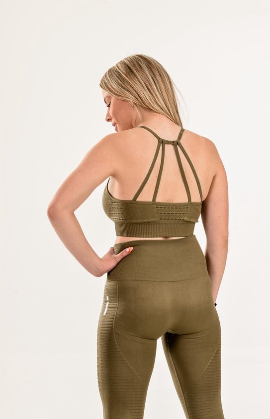 Achterkant van vrouw in khaki sport-bh met open rug en legging met "DM TRAINING" logo.