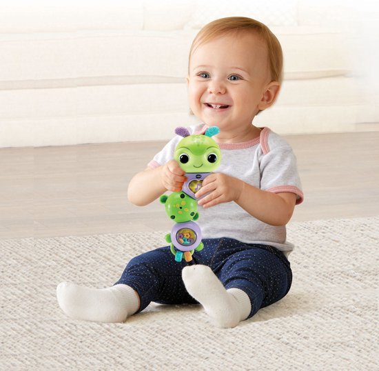 Baby met een groen rupsje in de handen.
