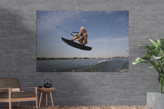 Une femme sportive s'agenouille sur un poster de jardin wakeboard 180x120 cm - Toile de jardin / Toile d'extérieur / Peintures d'extérieur (décoration de jardin) XXL / Groot format!