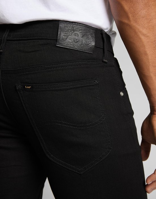 Close-up van de achterkant van een zwarte Lee jeans met een leren label met Lee logo.