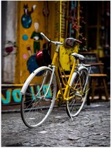 WallClassics - Poster Glanzend – Gele Fiets in de Stad - 60x80 cm Foto op Posterpapier met Glanzende Afwerking