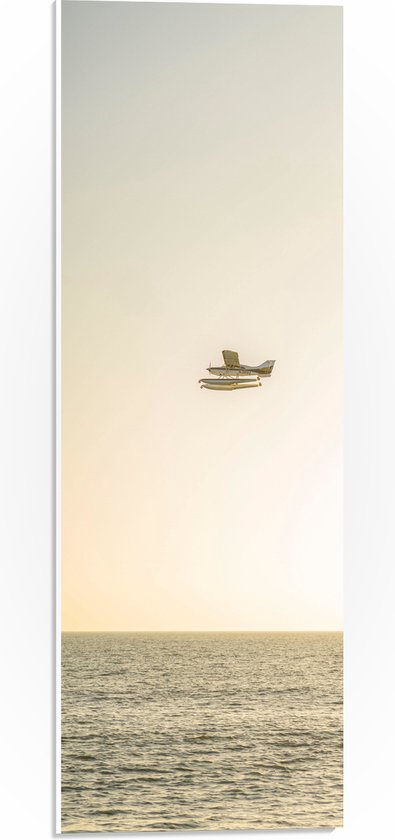 WallClassics - PVC Schuimplaat- Vliegtuig Vliegend boven Water met Boeien bij Lichtkleurige Lucht - 20x60 cm Foto op PVC Schuimplaat