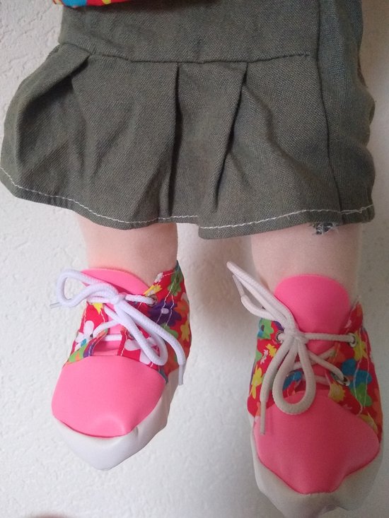 Roze schoentjes met witte veters en een bloemenprint in levendige kleuren.