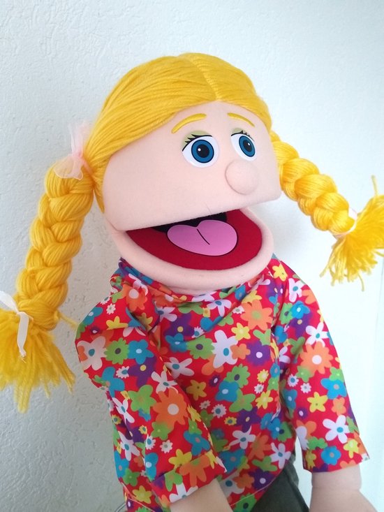 Buiksprekpop Cindy met blonde vlechten, blauwe ogen en een kleurrijke bloemenblouse.