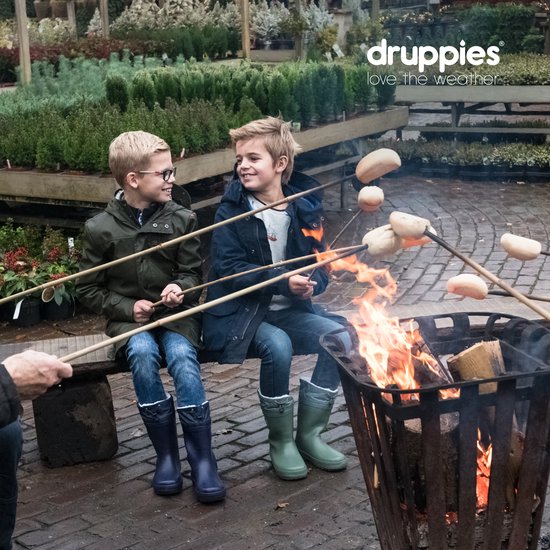 Twee jongens zitten bij een kampvuur, roosteren broodjes. Ze dragen winterjassen en laarzen in verschillende kleuren.