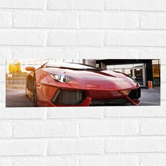 Muursticker - Rode Sportauto Geparkeerd voor Gebouw - 60x20 cm Foto op Muursticker