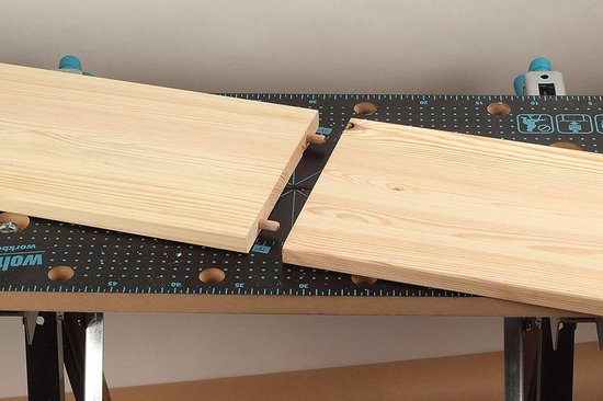 Twee houten planken verbonden met deuvels, geplaatst op Wolfcraft werkbank.