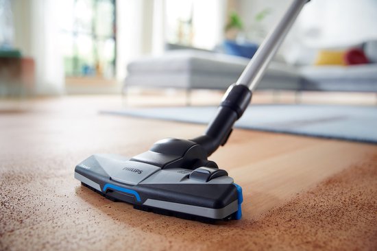 Het TriActive+ mondstuk van een Philips stofzuiger op een houten vloer.