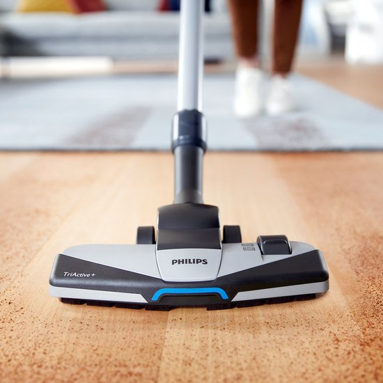 Het TriActive+ mondstuk van een Philips stofzuiger op een houten vloer.