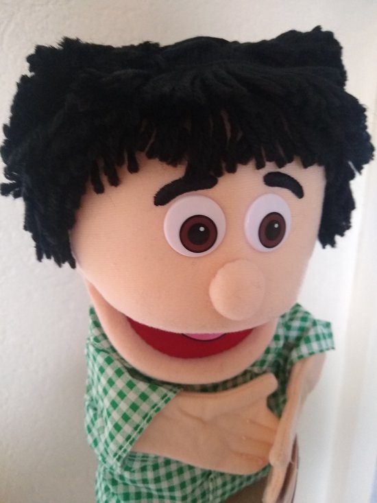 Close-up van handpop Kennie met zwarte haren en groene geruite blouse.