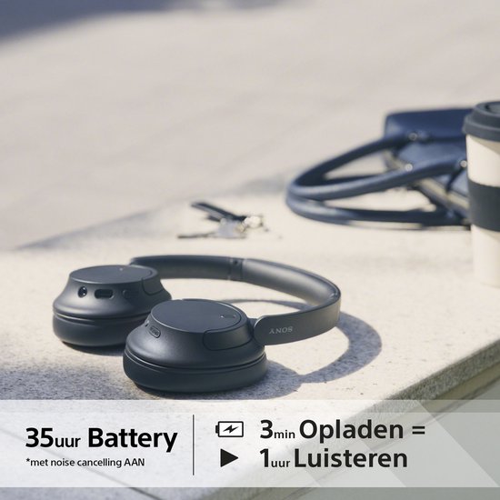 Zwarte Sony koptelefoon op een stenen rand. '35 uur batterij, 3 min opladen = 1 uur luisteren'.