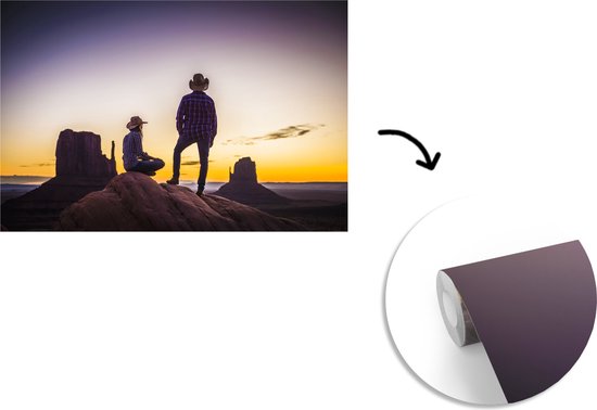 Deux cowboys dans une zone de montagne au coucher du soleil fotobehang