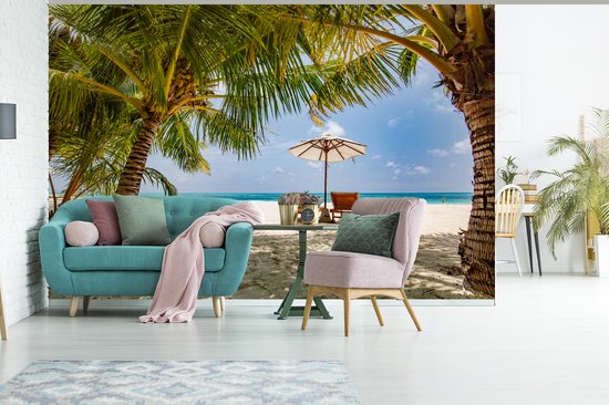 Chaises longues entre les palmiers sur une plage de Bali fotobehang