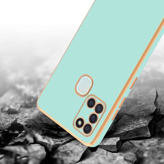 Mintgroen telefoonhoesje met gouden rand, vallend op gebarsten ondergrond.