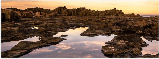 Poster Glanzend – Helder Bruine Rotsen in Water met Paarse Gloed - 60x20 cm Foto op Posterpapier met Glanzende Afwerking