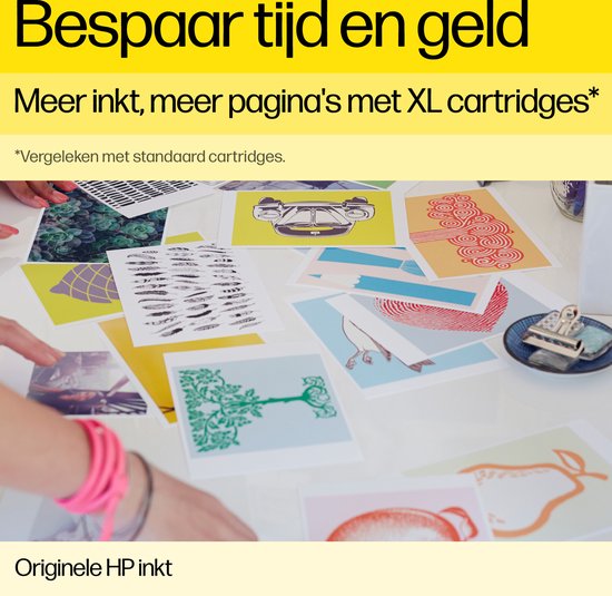 Een tafel vol kleurrijke prints, een hand met roze armband houdt een print vast.