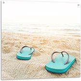 Tuinposter – Blauw Paar Slippers op Strand aan de Zee - 100x100 cm Foto op Tuinposter (wanddecoratie voor buiten en binnen)