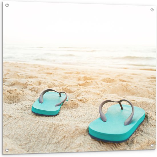 Tuinposter – Blauw Paar Slippers op Strand aan de Zee - 100x100 cm Foto op Tuinposter (wanddecoratie voor buiten en binnen)