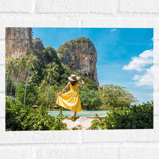 Muursticker - Meisje in Gele Jurk in Natuurlandschap met Palmbomen en Rotsen - 40x30 cm Foto op Muursticker