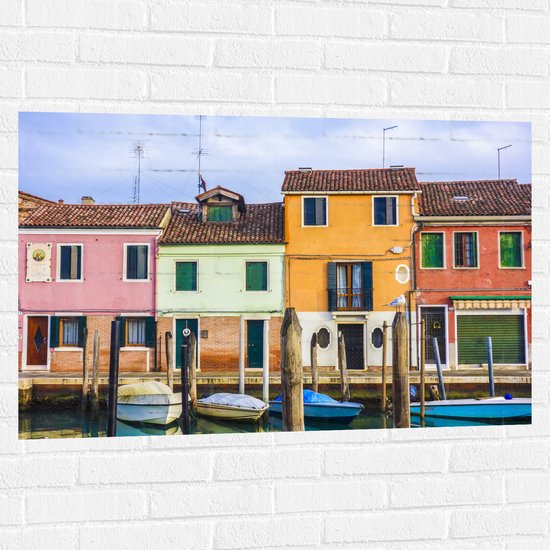 WallClassics - Muursticker - Gekleurde Huizen aan het Water met Boten - 105x70 cm Foto op Muursticker