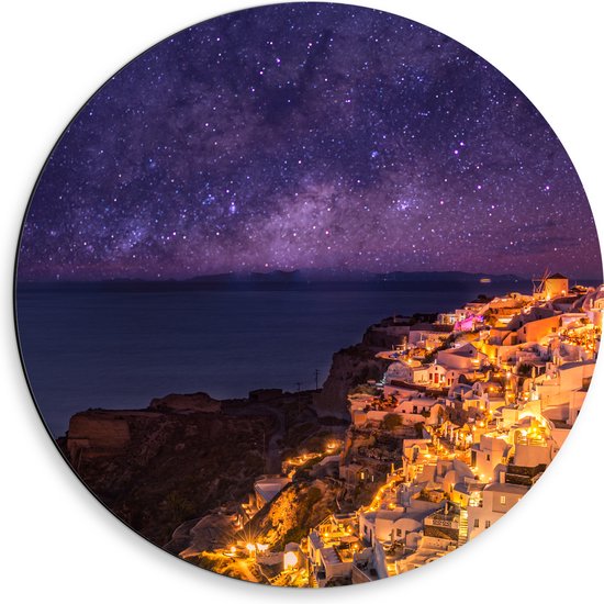 Dibond Muurcirkel - Verlicht Dorp in de Nacht aan het water met de Melkweg in de Lucht - 50x50 cm Foto op Aluminium Muurcirkel (met ophangsysteem)