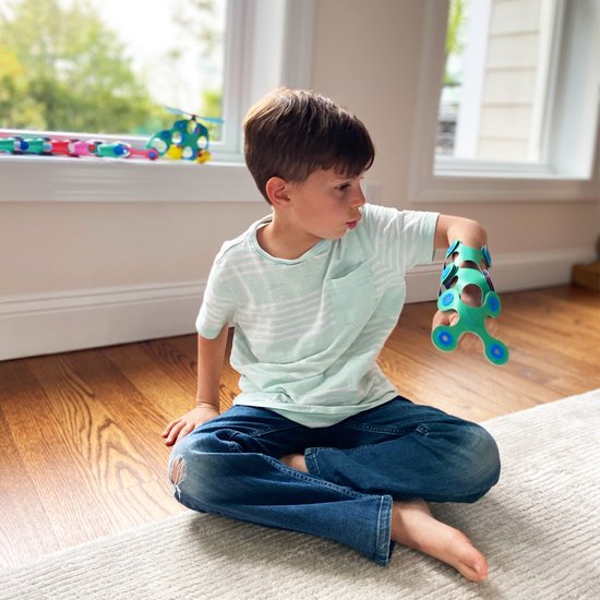 Jongen met een mintgroen gestreept shirt, spijkerbroek en een groen Clixo-armband op zijn arm.