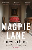 Boekomslag met de titel 'Magpie Lane' van Lucy Atkins. Een gang met een rode bank en schilderijen.