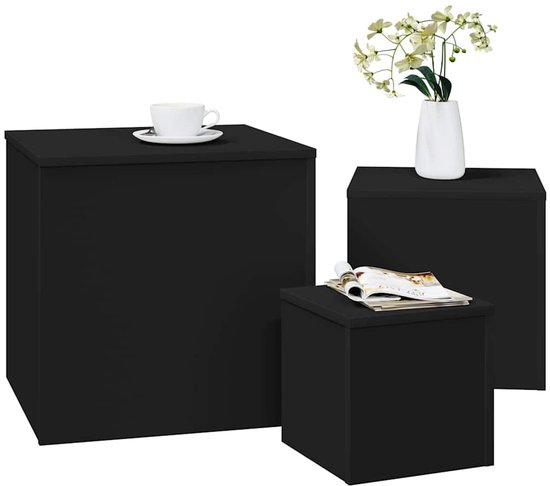 Drie zwarte kubusvormige bijzettafels van verschillende groottes, één met een kopje koffie, één met tijdschriften, en één met een vaas.