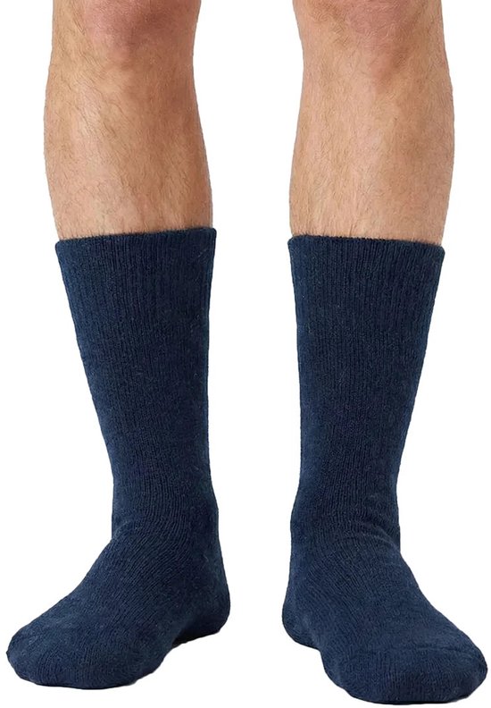 Een paar marineblauwe, dikke wollen sokken tot halverwege de kuit, gedragen door een man.