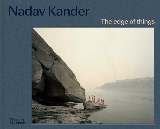 Boek 'Nadav Kander: The edge of things' met op de voorkant een foto van een rotsformatie aan het water met een groep mensen erop.