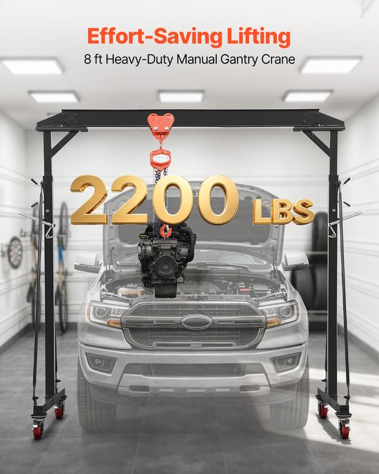 Zwarte portaalkraan tilt een motor met 2200 lbs in een garage boven een pickup truck. Tekst: "Effort-Saving Lifting 8 ft Heavy-Duty Manual Gantry Crane".