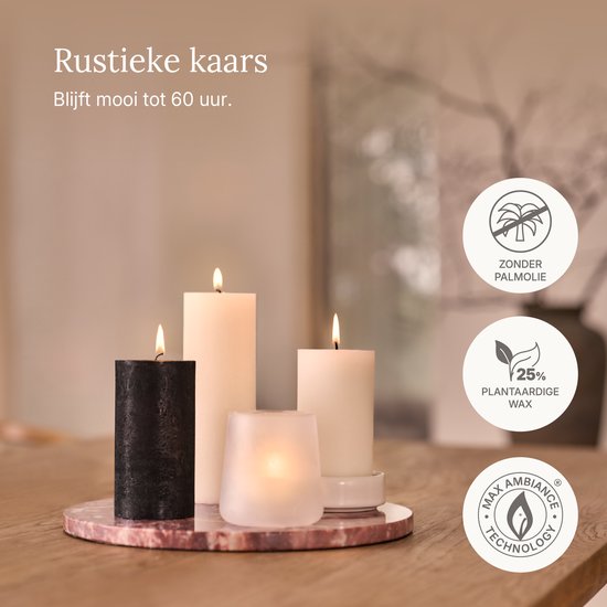 Vier brandende kaarsen: zwart, ivoor en twee in een glazen houder.