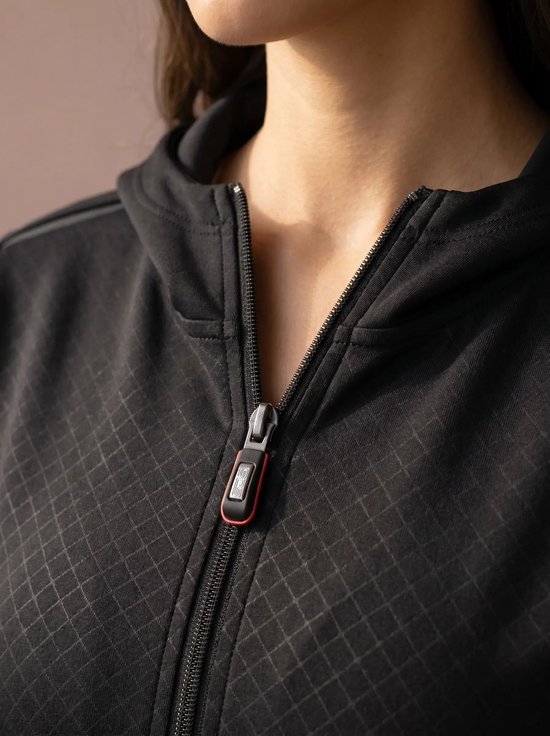 Close-up van de rits van een zwarte hoodie met een ruitpatroon. De rits heeft een rode en grijze trekker.