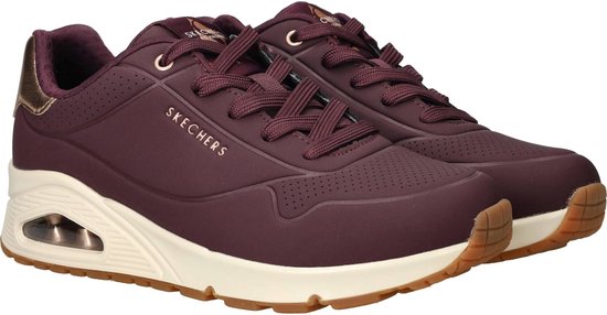 Paarse Skechers sneakers met beige zool, gouden hielaccent en perforaties.