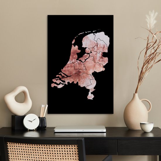 Affiche des Pays-Bas en teintes rose délavé avec bordure noire, suspendu à un mur taupe au-dessus d'un bureau.
