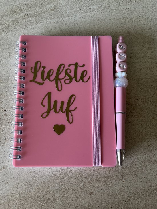 Roze notitieboekje met gouden tekst "Liefste juf" en een hartje, met een roze pen met 'JUF' kralen.