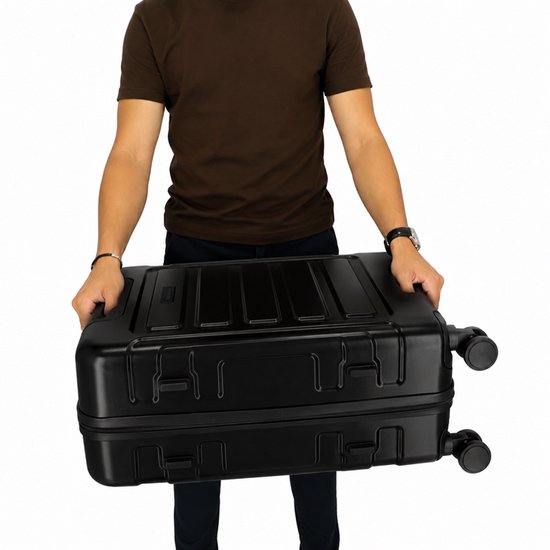 Man in bruin T-shirt met zwarte koffer met vier wielen.