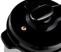 Close-up van het zwarte deksel van een Tefal multicooker met een drukknop en een oranje indicatielampje.