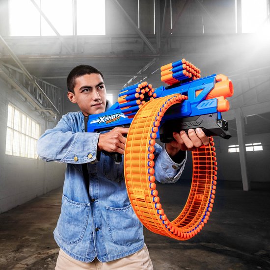 Man in spijkerjack met blauwe en oranje speelgoedblaster met rond magazijn.