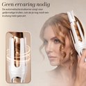 Een vrouw met golvend rood haar gebruikt de Sansbeauté automatische krultang.