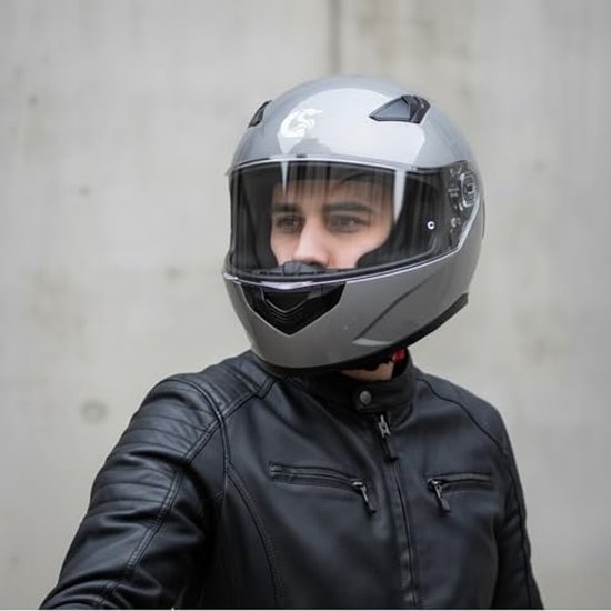 Man met matgrijze integraalhelm met zwart leren jack, met grijs op de achtergrond.