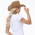 Een blonde vrouw met een opengewerkte bruine strooien cowboyhoed en een witte t-shirt.