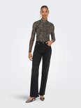 Model in zwart-bruine panterprint mesh coltrui met lange mouwen, gedragen met wijde jeans.