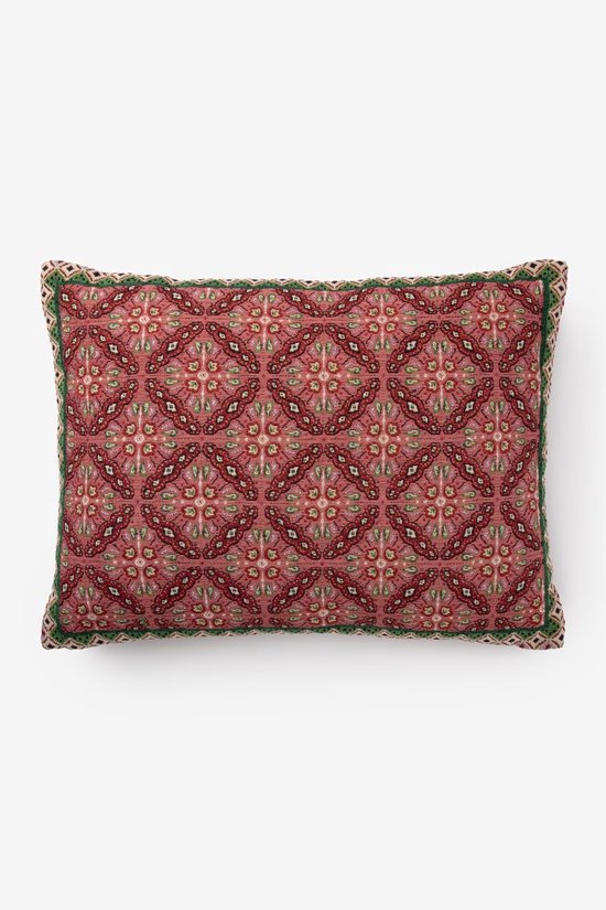 Kussen met een roze achtergrond en een veelkleurige mozaïekprint in rood, groen en beige. Met groene bies en gevlochten rand.