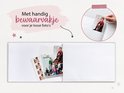 Een open schoolfotoboek met lege pagina's en een vak voor losse foto's. Tekst: "Met handig bewaarvakje voor je losse foto's".
