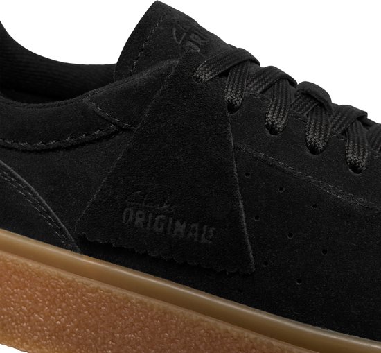 Close-up van het suède label 'clarks originals' op de zijkant van zwarte suède veterschoenen met crêpezool.