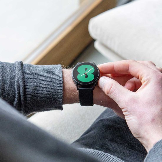 Een hand past het scherm aan van een smartwatch met een zwart bandje.
